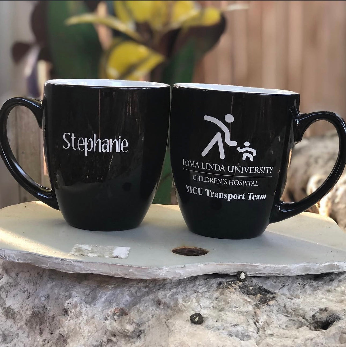 Two black mugs with white engravings